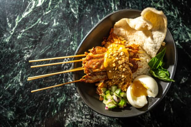 Chicken satay skewers with puffed rice and a poached egg for breakfast at Cedric and Ochi Vongeritchen's first solo venture, Wayan, in Manhattan. Photo by Noah Fecks.