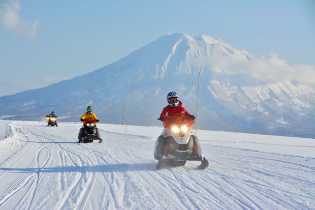 Snowmobiling in Niseko with Mount Yotei in the background. Photo by Niseko United