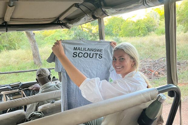 Indagare's Ali Malecka holds a Malilangwe Scouts t-shirt. Photo by Bridget McElroy courtesy Indagare