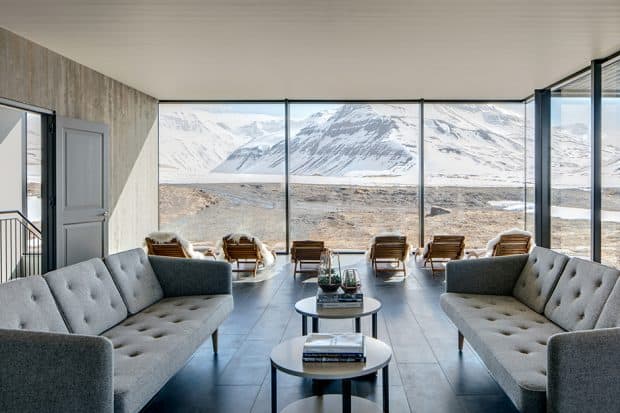 Minimalist lounge with 2 couches and snowy mountain view at Deplar Farm, Iceland