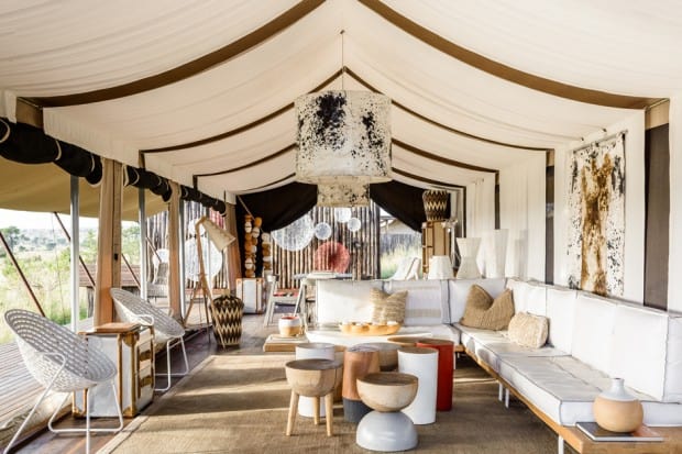 Tented lounge with white furniture at Singita Mara River Camp, Tanzania